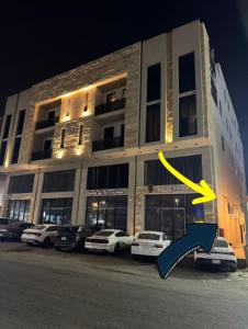 a large building with cars parked in front of it at The Rose Apartment الدمام in Al Fayşalīyah +31 photos