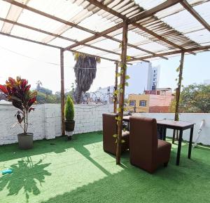 patio con tavolo e sedie sotto un baldacchino di Casona Turística Gonzales a Lima