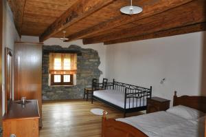 a bedroom with two beds and a stone wall at Pri Bregarju in Podsabotin