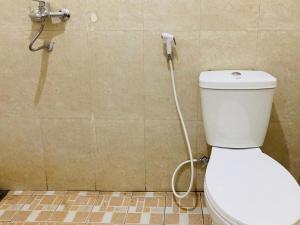 a bathroom with a toilet with a hose at RedDoorz near Jalan Malioboro Area in Ngabean