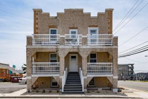 a brick building with a balcony and stairs on it at Artistic Oceanfront 2 Bedroom on the beach, Parking Beach Badges fun for all ages in Seaside Heights