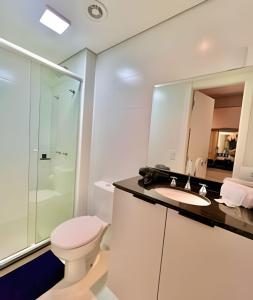 a bathroom with a toilet and a sink and a shower at STUDiO Moderno para sua Estadia Perfeita in Curitiba