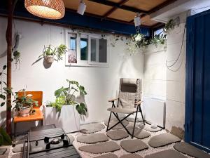 eine Außenterrasse mit einem Stuhl und Topfpflanzen in der Unterkunft 서울 성북 D'enough House in Seoul