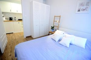 ソポトにあるVictus Apartamenty, Apartament Askjaの白いベッドルーム(白い枕の青いベッド付)