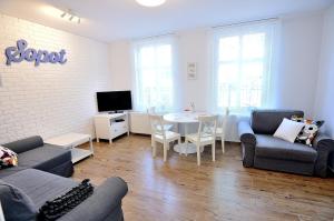 a living room with a couch and a table at Victus Apartamenty, Apartament Askja in Sopot