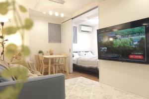 a living room with a flat screen tv on a wall at New Garfieldhome Shinjuku in Tokyo