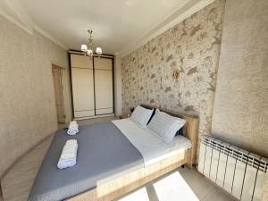 ビシュケクにあるAvenueのベッドルーム1室(青いシーツと白い枕のベッド1台付)