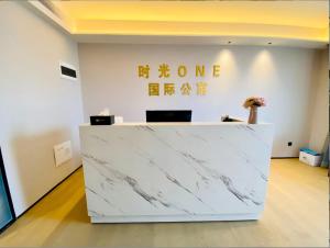 深圳时光ONE国际公寓（深圳福田口岸KKone下沙地铁站店）的房间里有白色大理石柜台，配有家庭祭坛