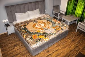 a bedroom with a bed with a floral blanket on it at Hotel Fast Way Manali #Near zingbus #Near Pizzahut #By Linkway in Manāli