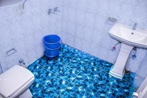 a blue floor in a bathroom with a toilet and a sink at Hotel Fast Way Manali #Near zingbus #Near Pizzahut #By Linkway in Manāli
