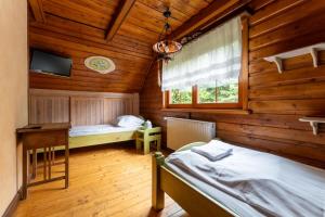 a room with two beds and a desk and a window at Domek Góralski przyjazny zwierzętom - ogrodzony - Blisko szlaków i aquaparku - z prywatną sauną, ogrodem in Karpacz