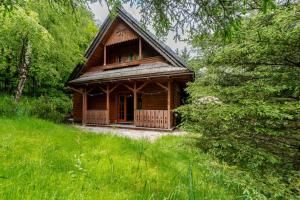 a wooden cabin in the middle of a forest at Domek Góralski przyjazny zwierzętom - ogrodzony - Blisko szlaków i aquaparku - z prywatną sauną, ogrodem in Karpacz