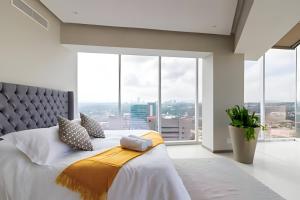 Un dormitorio con una cama grande y grandes ventanales. en Parklife Pabellón, en Guadalajara 277 fotos más