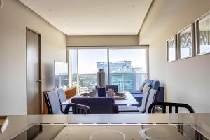 Un comedor con mesa y sillas y una gran ventana. en Parklife Pabellón, en Guadalajara