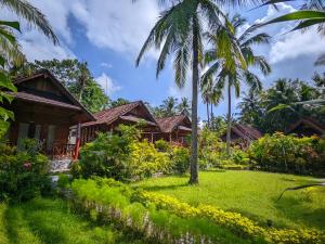 a row of cottages in a resort with palm trees at Dangin Kubu in Toyapakeh