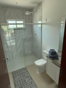 ein Badezimmer mit Toilette und Glasdusche in der Unterkunft Malicia Ranch in Lagoa do Boi + 22 Fotos