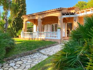 une maison avec une clôture blanche et une cour dans l'établissement Villa au calme à Sanary, climatisée, avec piscine, à Sanary-sur-Mer