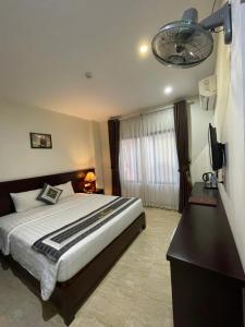 a bedroom with a bed and a television in it at New Sun Hotel in Ha Long
