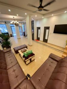 a living room with couches and a tv and a couch at New Sun Hotel in Ha Long