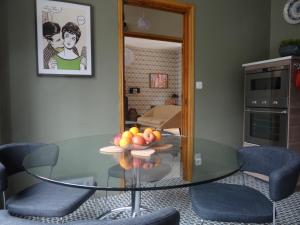 een glazen tafel in een woonkamer met een fruitschaal bij L'Art Du Temps le Gîte in Montreuil-sur-Mer
