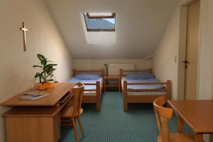 a room with two beds and a table and chairs at Luise Wehrenfennig & Haus EvA in Bad Goisern