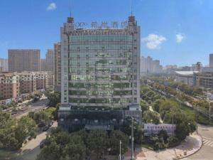 un grand bâtiment avec une enseigne au sommet dans l'établissement Xana Lite Yichun Fengcheng Municipal Government Branch, à Sunjiadu