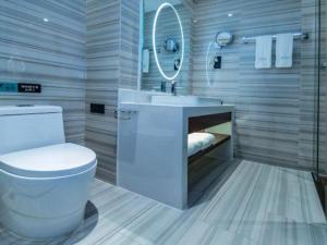 une salle de bain avec toilettes, lavabo et miroir dans l'établissement Xana Lite Yichun Fengcheng Municipal Government Branch, à Sunjiadu 261 autres photos