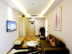 un salon avec un canapé et une table dans l'établissement Lavande Hotels Pei County Hanyuan Avenue, à Pei