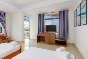 a bedroom with two beds and a flat screen tv at Nhà Khách 258 - Sea Front - Near Mikazuki - 500m in Da Nang