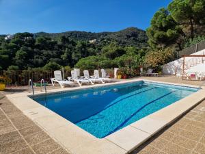 a swimming pool with lounge chairs and a mountain at Villa Alella, 5 bedrooms & pool in Alella