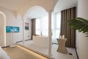 a bathroom with a white tub and a large window at Town Designer B&B in Qingdao