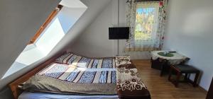 a bedroom with a bed and a table and a window at Pokoje U Wandy in Łeba