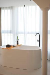 a large white tub in front of a window at Town Designer B&B in Qingdao