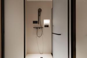 a shower with a shower head in a room at Town Designer B&B in Qingdao