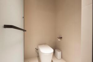 a bathroom with a white toilet in a room at Town Designer B&B in Qingdao