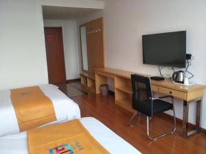a hotel room with a desk and a television at PAI Hotel·Xuzhou Pei Country, Yangtun Economic and Technological Development Zone Shiliu K in Datun
