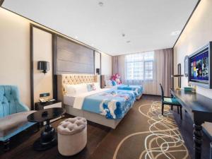 a hotel room with a large bed and a desk at Xana Hotelle·Yutian in Tangshan +214 photos