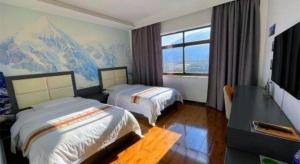 ein Hotelzimmer mit zwei Betten und einem Fenster in der Unterkunft Shell Linzhi Bayi Area G318 Shuangyong Road Hotel in Dagzê