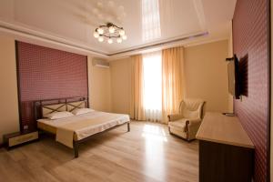 a bedroom with a bed and a chair and a television at Center Hotel in Bishkek +14 photos