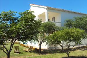 a white house with trees in front of it at Apartments Marko in Vrsi