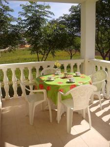 a table and chairs on a porch with a green table and chairs at Apartments Marko in Vrsi +91 photos