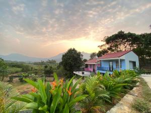 a house with the sunset in the background at Kame Healing Garden in Ba Vì