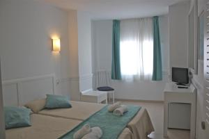 a bedroom with a bed with towels on it at Hostal Brisa Marina in Port d'Alcudia
