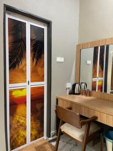 a desk with a mirror and a table with a chair at Suria guesthouse in Kampung Raja
