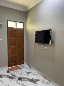 a room with a door and a television on the wall at Suria guesthouse in Kampung Raja