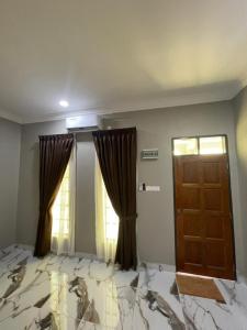 an empty room with a door and a window at Suria guesthouse in Kampung Raja