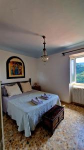 a bedroom with a bed with a chandelier and a window at Tuscany, Loro Ciuffenna Mountain Bike&walking in San Clemente in Valle
