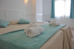 a bed with two towels on top of it at Hostal Brisa Marina in Port d'Alcudia
