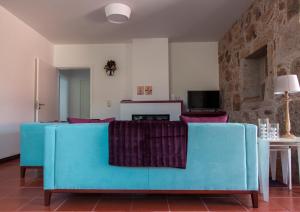 アルコス・デ・ヴァルデヴェスにあるQuinta do Cerqueiralの青いソファとテーブルのあるリビングルーム