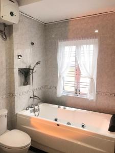 a bathroom with a tub and a toilet and a window at DU Home Huế in Thôn An Hòa +35 photos